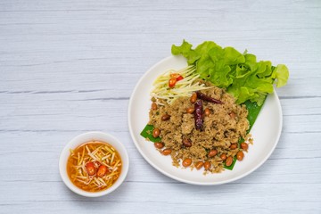 Crispy Catfish spicy Salad Served With Shredded Green Mangoes,green Cabbage, fried dried Chilies and Peanuts fried Isolated on White Background. Famous traditional food in Thailand and Asia.