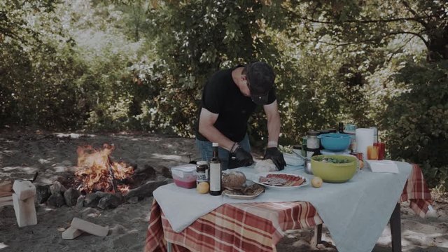 a man in the field cook food. In the forest near the fire. Field kitchen