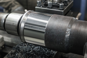 Turning lathe in action. Facing operation of metal blank on turning machine with cutting tool. Old turning lathe machine in turning workshop. Operator machining high precision mold part by cnc lathe