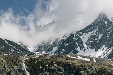 Fototapeta premium Peak of the mountains in the clouds on a background of blue sky.