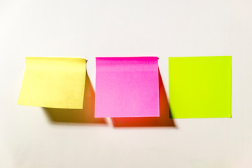 Multi-colored square post-it notes pasted on a white wall