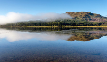 Misty dawn on Loch Eil calm with perfect reflections