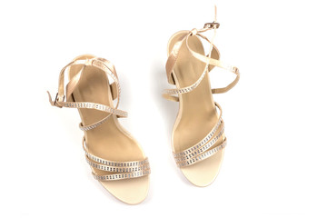 Close-up of beautiful, stylish women's beige sandals with rhinestones on high heels. The view from the top