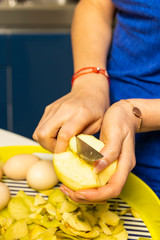 Woman cooking and cutting apple on wooden cutting board. Preparing healthy food.
