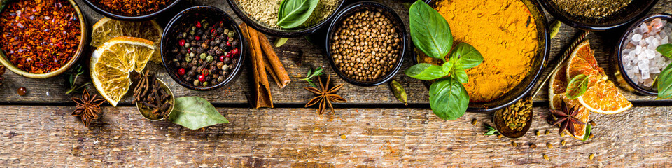 Set of Spices and herbs for cooking. Small bowls with colorful  seasonings and spices - basil, pepper, saffron, salt, paprika, turmeric. On rustic wooden plank table background, top view copy space - Powered by Adobe