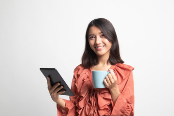 Fototapeta premium Young Asian woman with a computer tablet and coffee .