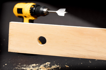 closeup of the hole made by a wood boring spade bit drilling in a piece of wood with an electric...