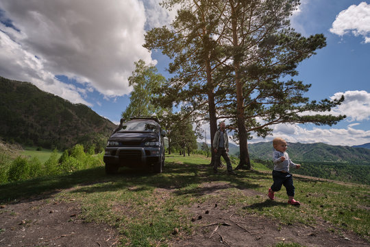 Father and kid in car off road mountain travel, summer vacation