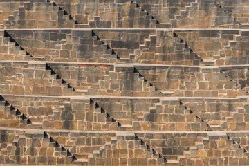 .Perspective background of stone stairs of Chand Baori Step Well in Abhaneri, Rajasthan, India. Stepwells in which the water is reached by descending a set of steps to the water level