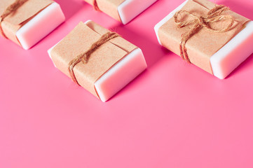 Row of packaged soap for hand washing on pink desk in bathroom. Hygiene concept