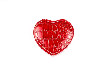 Close-up of a red leather jewelry box in the shape of a heart, on a white background. The view from the top. The concept of gifts and love. Copy space.