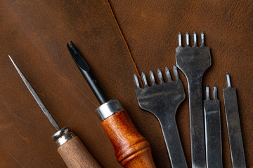 Leather craftsman tools on leather. Set of leather craft tools