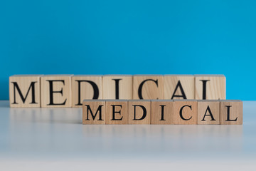 Medical text from wooden cubes. White backdrop blue background. Studio