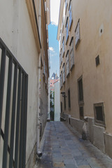 Narrow street in Vienna with urban cityscape view. Historic landmarks from the touristic roads in the capital of Austria. Facade of buildings from the sides. 