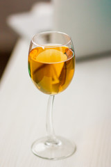 a glass of apple juice, a golden drink in а high standing glass
