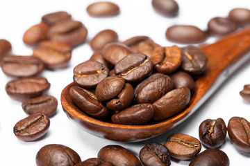 Extreme close up coffee beans in wooden spoons isolated on a white background/ select focus.