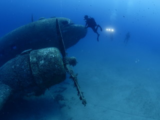 airplane wreck underwater with propeller airplane engine scuba divers to explore