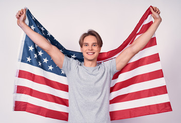 Happy young guy with american flag on a white background.