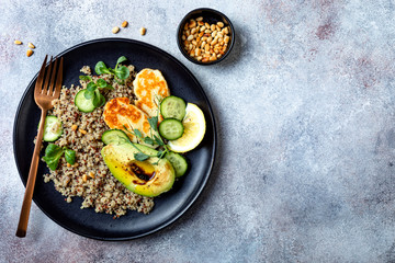 Grilled Halloumi cheese salad with quinoa, avocado, cucumber, toasted pine nuts dressed with honey balsamic vinaigrette. Healthy vegetarian dinner