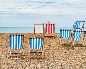 Typical English Summer. Deckchairs on the pebble beach. Brighton, East Sussex, England, United...