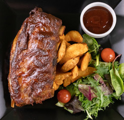 Baked pork ribs with barbecue or BBQ sauce and wedges