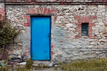 a picture of the old brick countryside barn with contrast blue door and some grass and trees concept for website background