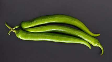 three green pepper on grey background. food and vegetable concept wallpaper.