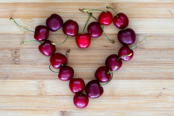 heart shape from red fresh cherries on chopping board, valentine's day concept wallpaper. food and fruits