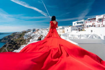 Woman In Red Waving Beautiful Dress With Flying Fabric, Fashion Model in Oia, Santorini, Greece