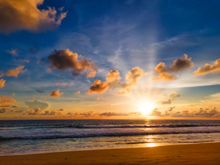 Naklejka na ściany i meble Colorfull tropical beach sunset with yellow, blue sky and sun ray with copy space. sunset over sea at Phuket beach, Thailand.
