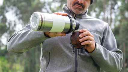 Mate drinking with a man pouring hot water