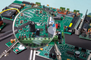 A glass magnifier with a focus on electronic waste printed circuit Board.