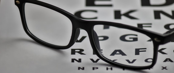gafas colocadas sobre un folio con letras para poder graduar la vista