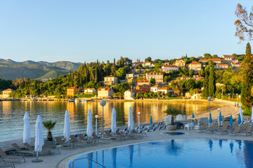 Beachside tourist hotel resort on Koločep Island (Elaphiti Islands) with swimming pool at sunset,...