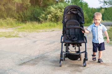 Boy. A blond boy, child drives a stroller. Independent child