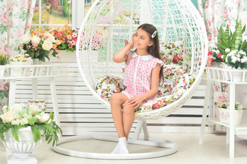 Fototapeta na wymiar Portrait of happy little girl posing on swing