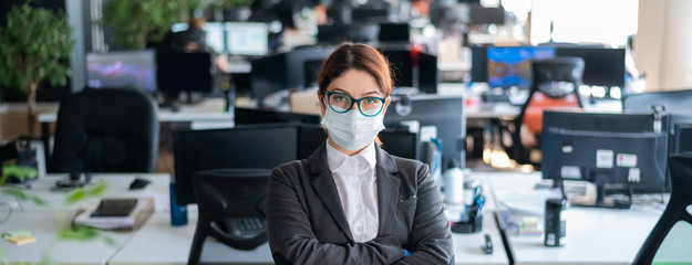 Business woman in office in a protective mask and gloves. Female manager with glasses and a suit...