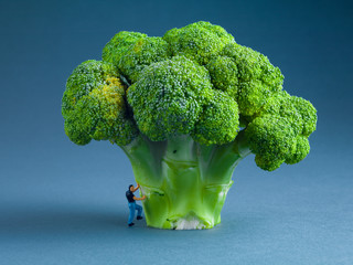 broccoli on a blue background with small men figures
