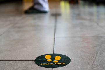 Fototapeta premium Stand here foot sign or symbol on the floor in coffee shop