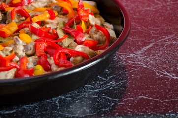 Meat casserole with vegetables close-up. Cooking process. Homemade side dish in the oven pan with copy space.