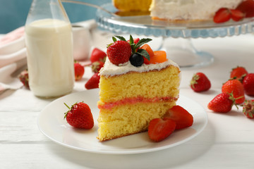 Composition with delicious berry cream cake on white wooden table. Tasty dessert