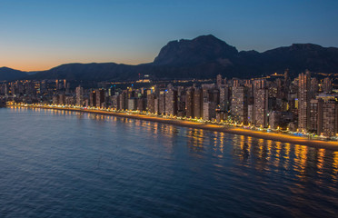 Fototapeta premium Night city by the sea with an empty beach and beautiful night lighting, Summer background