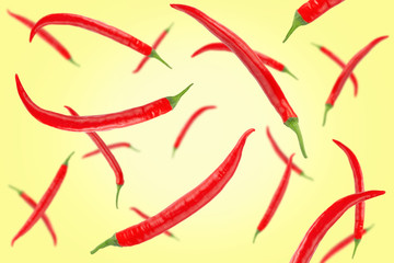 Falling red hot chilli peppers isolated on a colored background with clipping path as package design element and advertising. Flying vegetables. Top view.