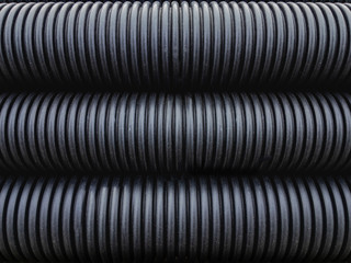 Plastic corrugated pipes in black under natural light. Background image.