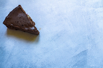 Chocolate brown cheesecake and slice on white table