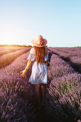 Girl with a hat on her head in the lavender field