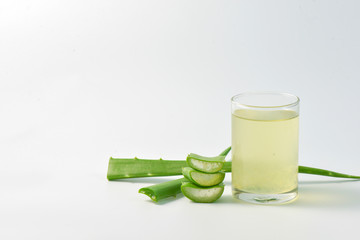 Aloe vera juice and leaves on white background