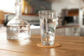 Glass of pure water and bottle on kitchen table