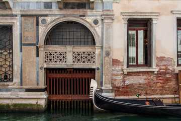 Fototapeta na wymiar Venice canal, gondola next to a beautiful wall