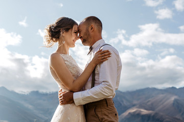 Bride and Groom standing on the top of mountain